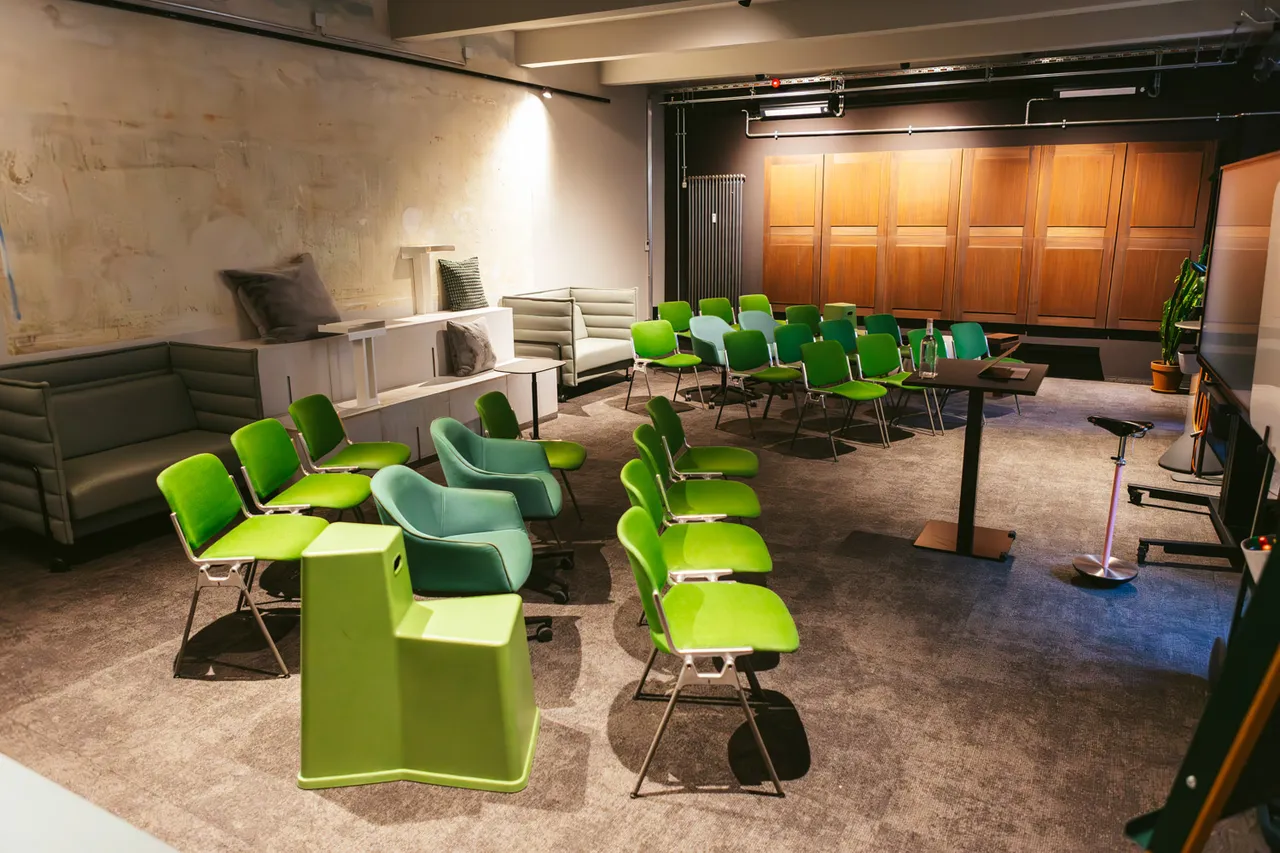 Atelier im club199 Nürnberg mit Stuhlreihen, Lounge-Sofas und Screen